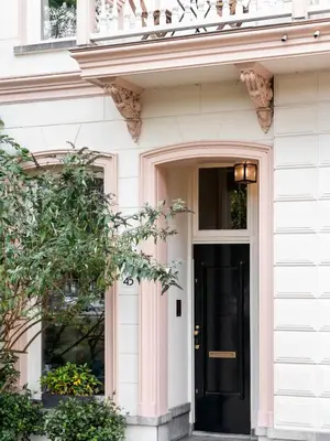 a white house with a black door and a window at Spinoza Suites in Amsterdam