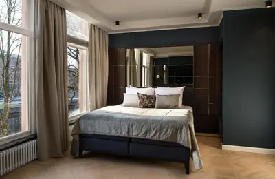 a bedroom with a bed and a large window at Spinoza Suites in Amsterdam