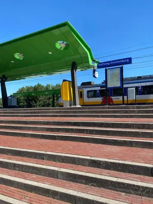 a train station with stairs and a green roof at Hotel de Keizerskroon Amsterdam-Schiphol-Halfweg in Halfweg