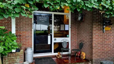 a front door of a brick building with a chair at City Farmer Amsterdam a Guesthouse with Bikes , Bed & Breakfast and Free Parking in Amsterdam