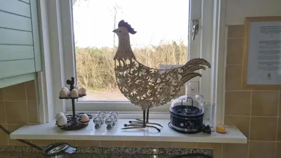 a statue of a chicken sitting on a window sill at City Farmer Amsterdam a Guesthouse with Bikes , Bed & Breakfast and Free Parking in Amsterdam