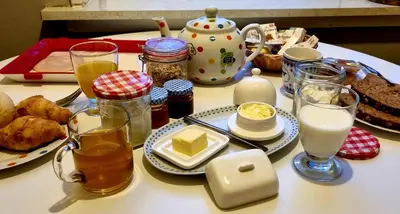 a table with plates of food and glasses of milk at City Farmer Amsterdam a Guesthouse with Bikes , Bed & Breakfast and Free Parking in Amsterdam