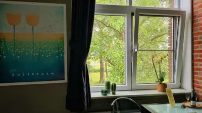 a kitchen window with a view of a tree at City Farmer Amsterdam a Guesthouse with Bikes , Bed & Breakfast and Free Parking in Amsterdam