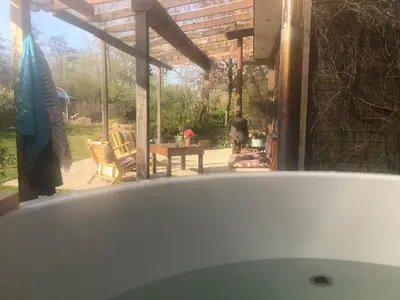 a bath tub in front of a patio with a table at De Aagt Tuyn in Schoorl