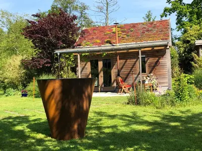 a small house with a tree stump in the yard at De Aagt Tuyn in Schoorl