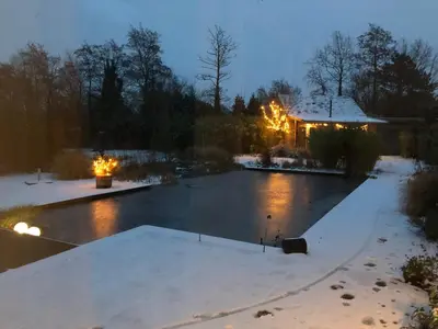 a swimming pool covered in snow at night at De Aagt Tuyn in Schoorl