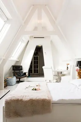 a white room with a bed and a table and chairs at Design B&B Naarden Vesting in Naarden
