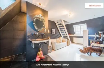 a living room with a girl sitting on the floor and a mirror at Design B&B Naarden Vesting in Naarden