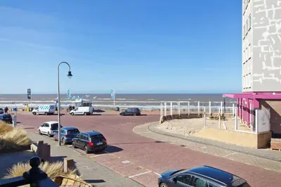 a parking lot with cars parked next to the beach at By Simonis in Zandvoort