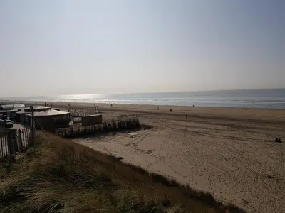 a view of a beach with people in the water at By Simonis in Zandvoort
