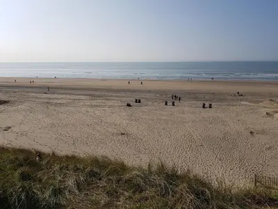 a group of people walking on a beach at By Simonis in Zandvoort
