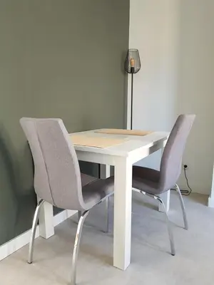 a white table with two chairs and a lamp at By Simonis in Zandvoort