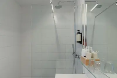 a bathroom with a shower with a mirror and a sink at Hotel Fita in Amsterdam