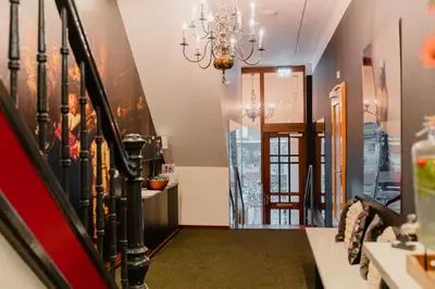 a hallway with a staircase and a chandelier at Hotel Fita in Amsterdam