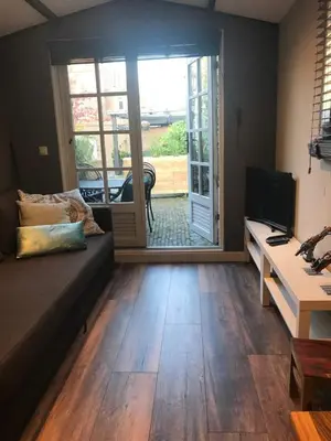 a living room with a couch and a sliding glass door at Beach House Milou zandvoort Private Parking in Zandvoort