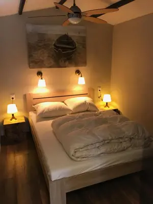 a bedroom with a bed with two lights on it at Beach House Milou zandvoort Private Parking in Zandvoort
