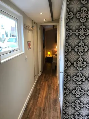 a hallway with a window and a wall of wallpaper at Beach House Milou zandvoort Private Parking in Zandvoort