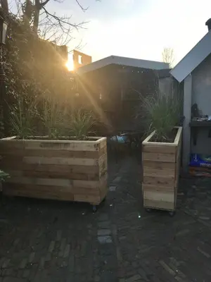 two wooden boxes with plants in them on a patio at Beach House Milou zandvoort Private Parking in Zandvoort