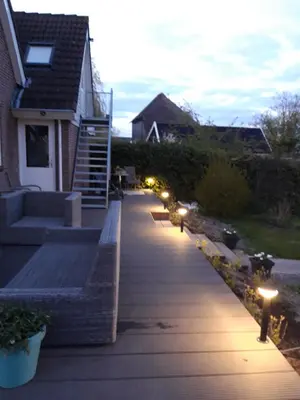 a walkway with lights in front of a house at Gastenverblijf appartement tussen Alkmaar en Hoorn in Oterleek
