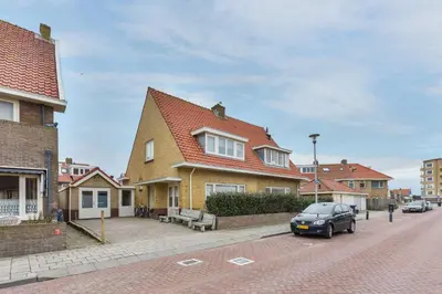 a car parked in front of a house on a street at Holiday Beach House in Zandvoort