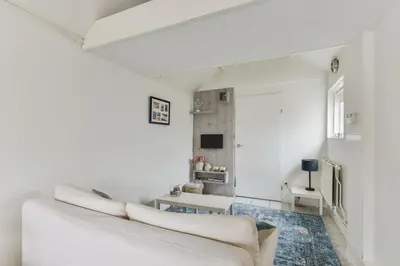 a white living room with a couch and a table at Holiday Beach House in Zandvoort