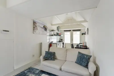 a living room with a white couch and a kitchen at Holiday Beach House in Zandvoort
