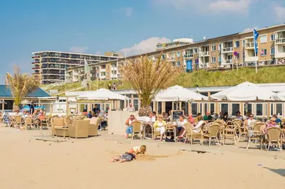 a child playing in the sand on the beach at Holiday Beach House in Zandvoort