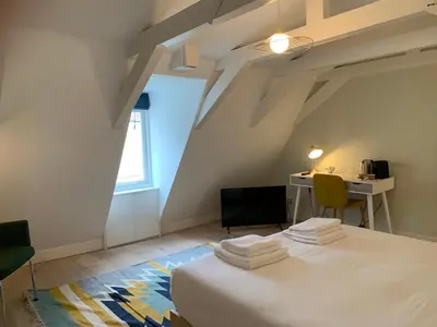 a room with a bed and a desk and a window at Kangaroom in Amsterdam