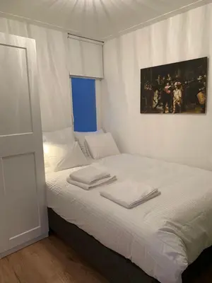 a bedroom with a white bed with towels on it at Kangaroom in Amsterdam