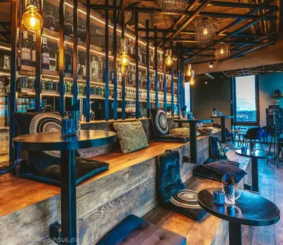 a restaurant with tables and chairs and a bar at Four Elements Hotel in Amsterdam