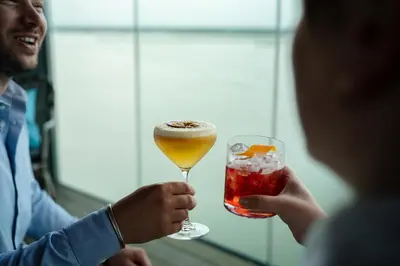 a man holding a glass of wine and a woman holding a drink at Four Elements Hotel in Amsterdam
