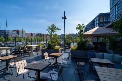 an outdoor patio with tables and chairs and buildings at Four Elements Hotel in Amsterdam