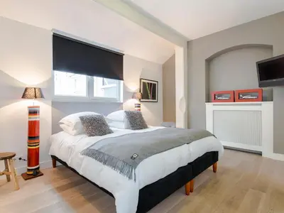 a bedroom with a large bed with a large window at Palm Apartment Amsterdam in Amsterdam