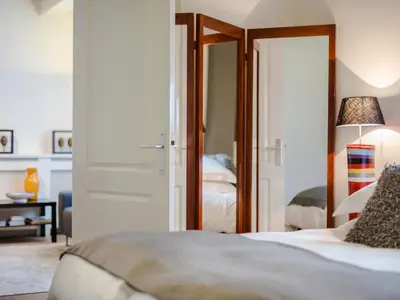 a bedroom with a bed and a door with a mirror at Palm Apartment Amsterdam in Amsterdam