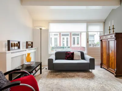 a living room with a couch and a chair at Palm Apartment Amsterdam in Amsterdam