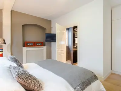 a bedroom with a white bed and a television at Palm Apartment Amsterdam in Amsterdam