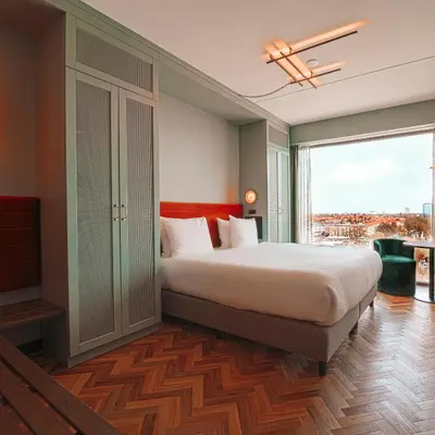 a bedroom with a large bed and a large window at Olympic Hotel in Amsterdam