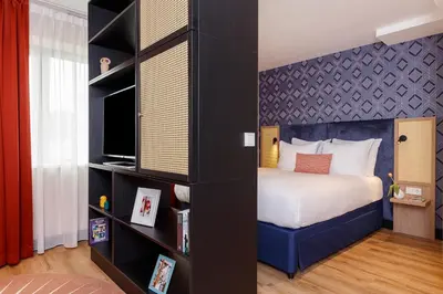 a bedroom with a bed and a book shelf at Citadines Sloterdijk Station Amsterdam in Amsterdam