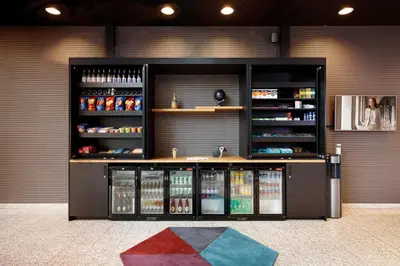 a store with a display case filled with drinks at Citadines Sloterdijk Station Amsterdam in Amsterdam