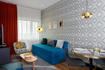 a living room with a blue couch and a table at Citadines Sloterdijk Station Amsterdam in Amsterdam