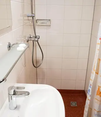 a bathroom with a shower with a toilet and a sink at Hotelboat Angeline in Amsterdam
