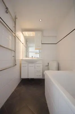 a white bathroom with a tub and a sink at 't Duinhuisje in Zandvoort