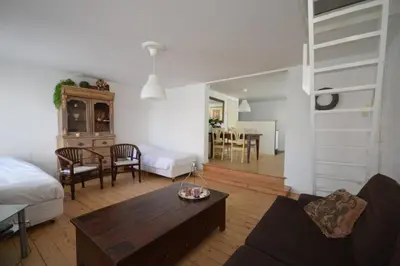 a living room with a bed and a table at 't Duinhuisje in Zandvoort