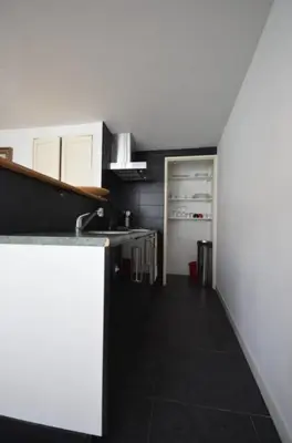 a kitchen with a sink and a refrigerator at 't Duinhuisje in Zandvoort