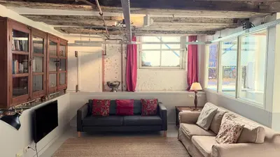a living room with a couch and a tv at Top-notch apartment along canal in historic centre in Amsterdam