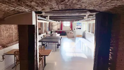 a room with tables and chairs in a building at Top-notch apartment along canal in historic centre in Amsterdam