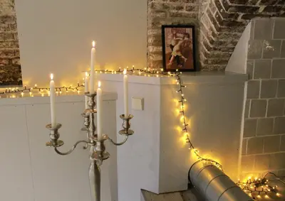 a candle in a room with christmas lights at Top-notch apartment along canal in historic centre in Amsterdam