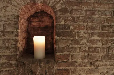 a white candle in a brick wall at Top-notch apartment along canal in historic centre in Amsterdam