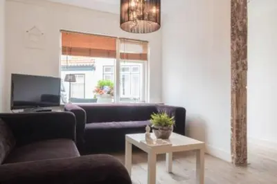 a living room with a couch and a table at 't Zandhuisje in Zandvoort
