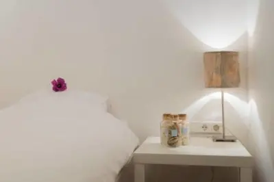 a bedroom with a bed and a table with a lamp at 't Zandhuisje in Zandvoort